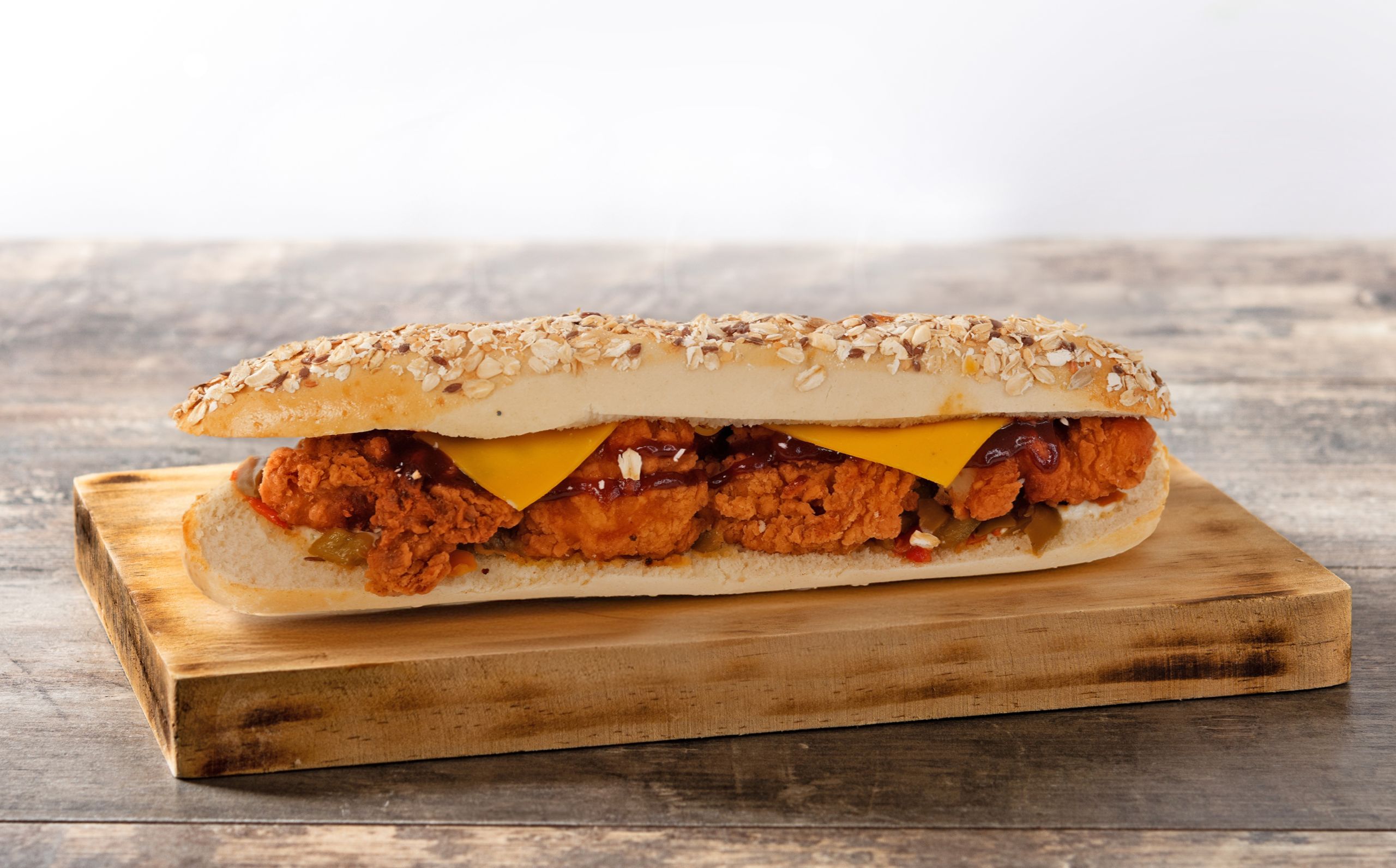 Submarine sandwich with ham, cheese, lettuce, tomatoes,onion, mortadella and sausage on wooden table