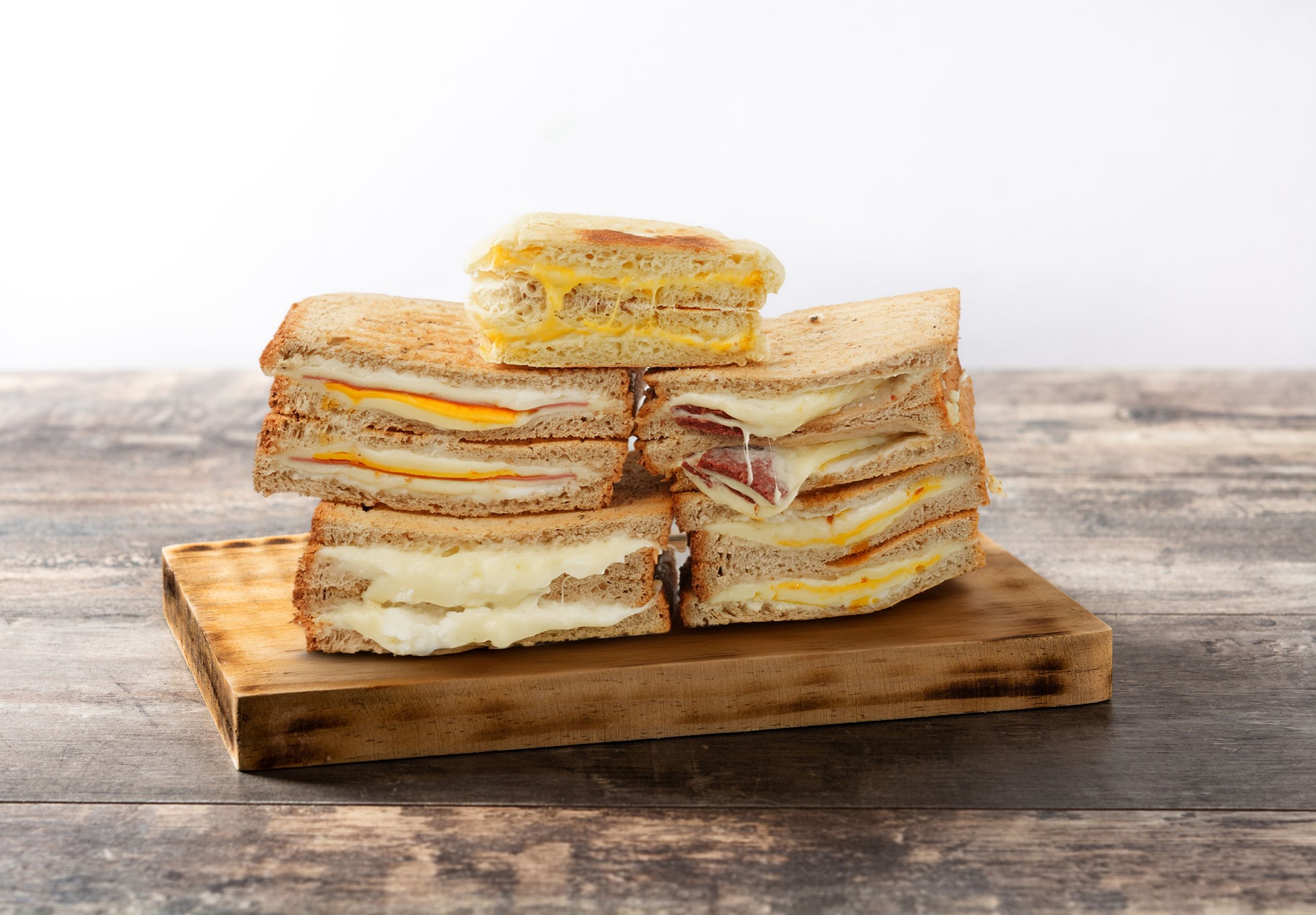 Submarine sandwich with ham, cheese, lettuce, tomatoes,onion, mortadella and sausage on wooden table